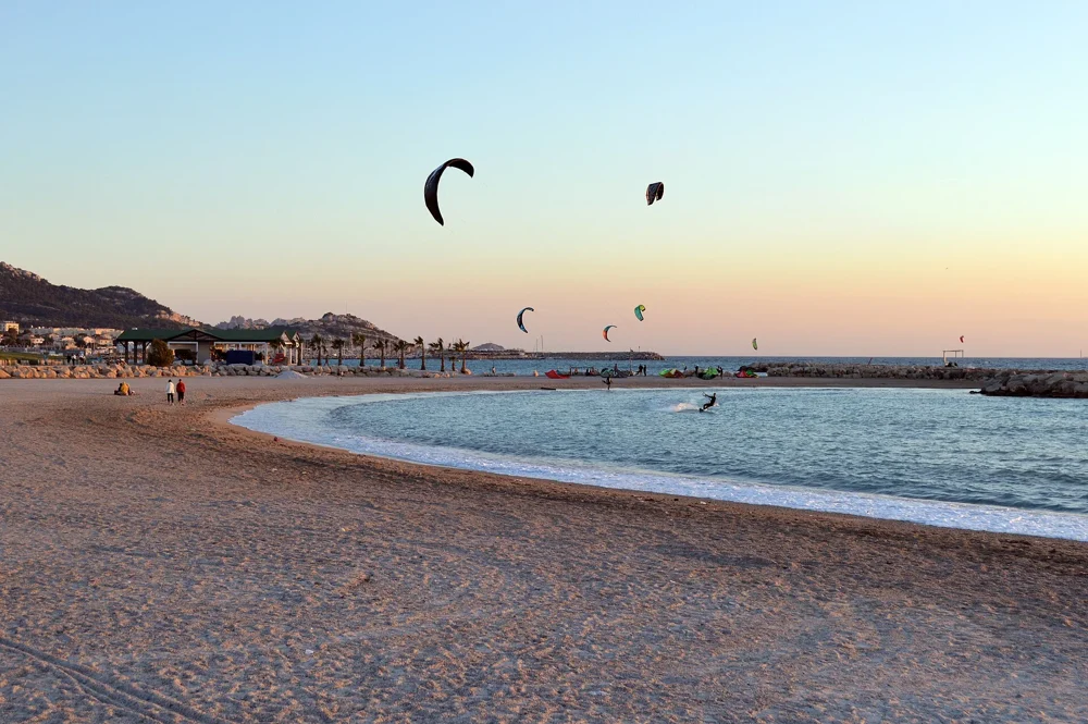 La plage de Bonneveine à Marseille au coucher du soleil, avec des kitesurfeurs