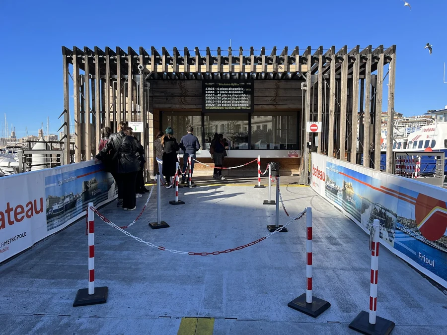 Embarcadère et billetterie du Vieux-Port de Marseille, avec les voyageurs qui attendent le bateau