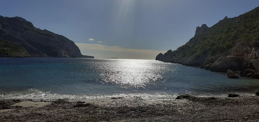 La calanque de Sormiou à Marseille, entre deux falaises, avec la mer éclairée par le soleil