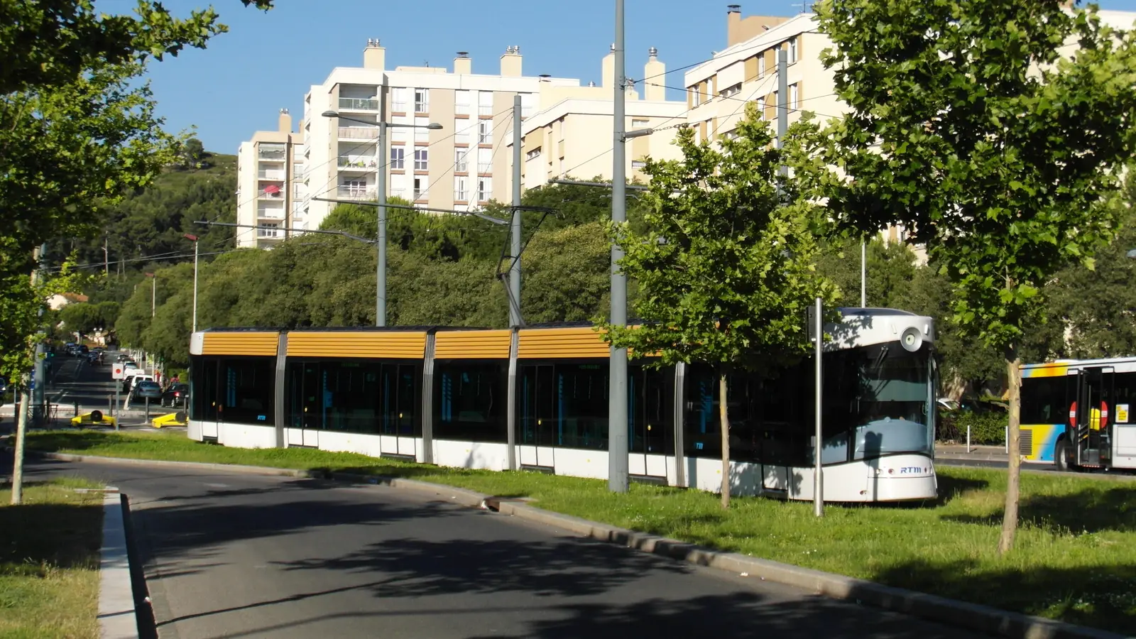 Rame du tramway T1 sur sa voie engazonnée aux Caillols, devant des immeubles du 12e arrondissement de Marseille