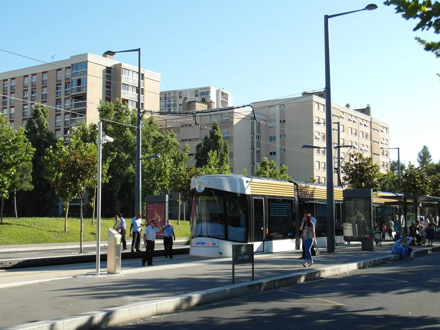 Rame du tramway T1 à l'arrêt Les Caillols, à Marseille, devant des immeubles du 12e arrondissement